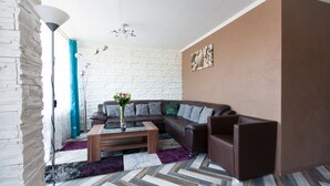 Un salon moderne avec un canapé d’angle, une table basse et un tapis à motifs.