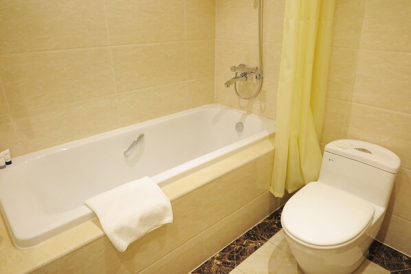 Une salle de bain avec une baignoire, des toilettes et une douche.