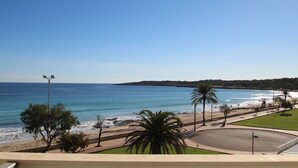 A coastal view with a beach, palm trees, and a clear sky. - Sa Maniga - sunny modern apartment, 3floors, on the beach up to 3per. WLAN incl. (Cala Millor)