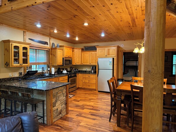 A spacious kitchen with wooden cabinets, a granite countertop, and a central island.