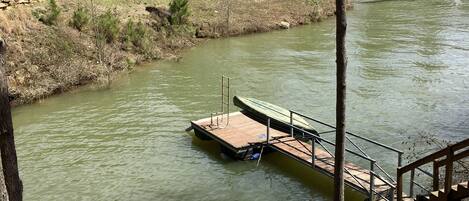 A river with a wooden dock and a stone wall.