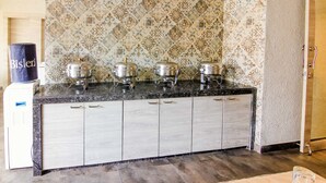 Una cocina con salpicadero estampado, encimera de granito y armarios de madera clara.
