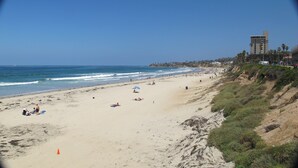 A beach with a clear view of the ocean and a building in the background. - Chic Beach Apartment..Steps to the sand! (San Diego)