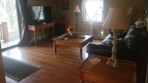Una sala de estar con una mesa de centro de madera, un sofá, un televisor y una chimenea.