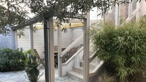 Un espacio al aire libre cubierto con escaleras, plantas en macetas y una estructura metálica.
