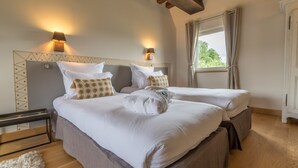 Une chambre d’hôtel avec deux lits, un plafond en bois et une fenêtre avec des rideaux.