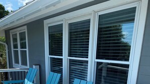 A porch with four blue Adirondack chairs and a wooden deck. - Sea Salt Cottage - Beach front neighborhood, next to downtown restaurants (Isle of Palms)
