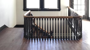 A spacious room with a wooden staircase and a large window. - Beautiful Farmhouse near Tuscaloosa (Fayette)