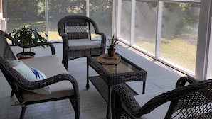 A covered porch with wicker furniture and potted plants. - Beautiful Farmhouse near Tuscaloosa (Fayette)