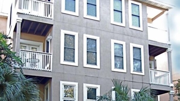 A multi-story residential building with a central staircase, balconies, and a well-maintained garden. - Stylish Townhome by K&P Hotel - LABOR DAY SPECIAL, 5 for 4; 4 for 3.5 (St. Simons Island)