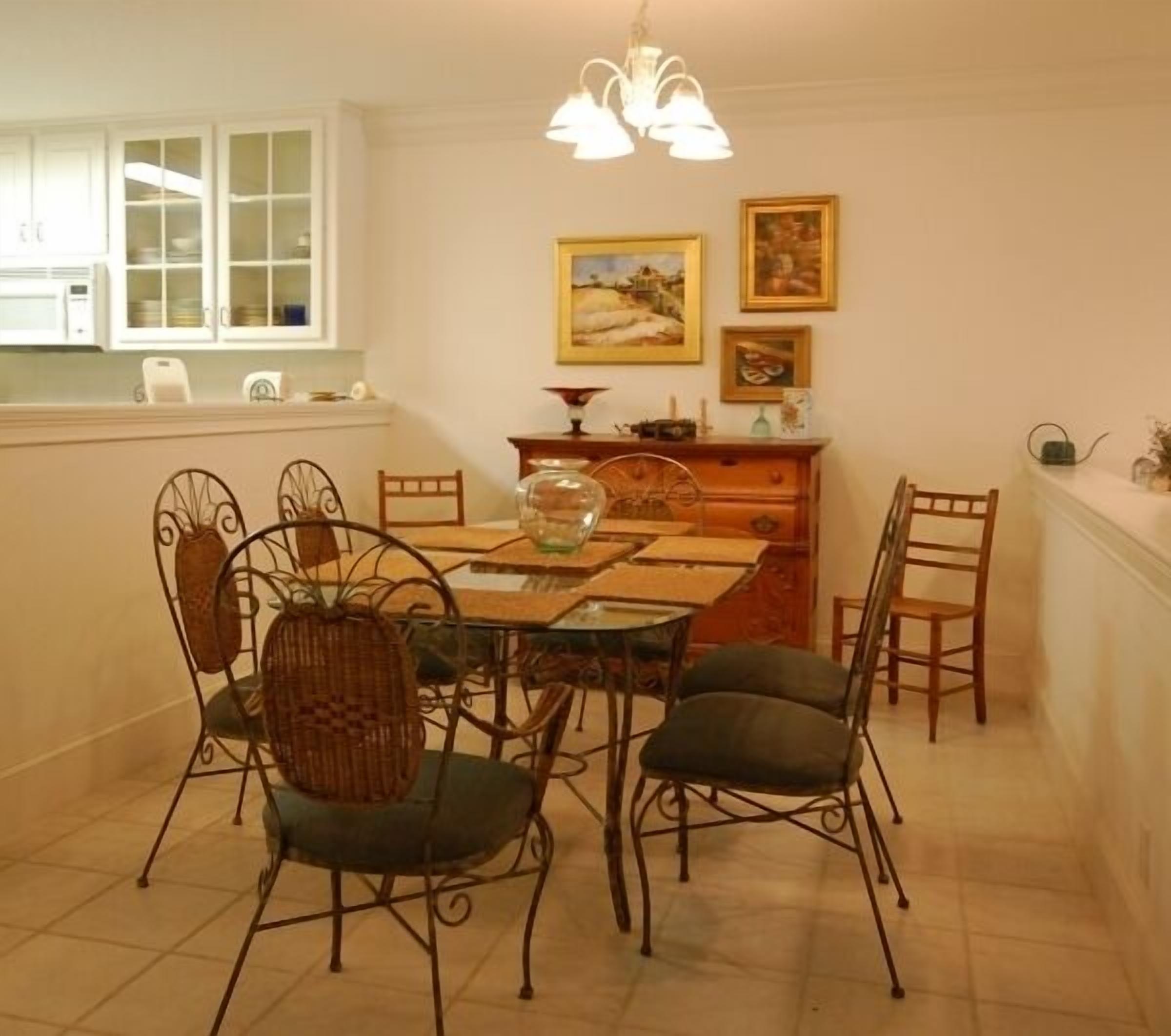 A dining area with a wooden table, metal chairs, and a chandelier.