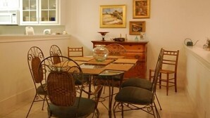 A dining area with a wooden table, metal chairs, and a chandelier. - Stylish Townhome by K&P Hotel - LABOR DAY SPECIAL, 5 for 4; 4 for 3.5 (St. Simons Island)