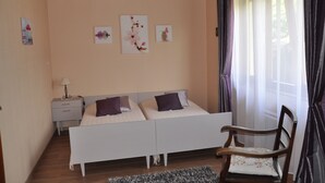 Un dormitorio con cama doble, una mesita de noche, una silla y tres obras de arte colgadas en la pared.