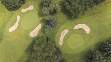 Vista aèria d'un camp de golf amb búnquers de sorra i arbres.