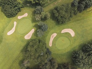 An aerial view of a golf course with sand bunkers and trees. - Hôtel Golf St Lazare (Limoges)