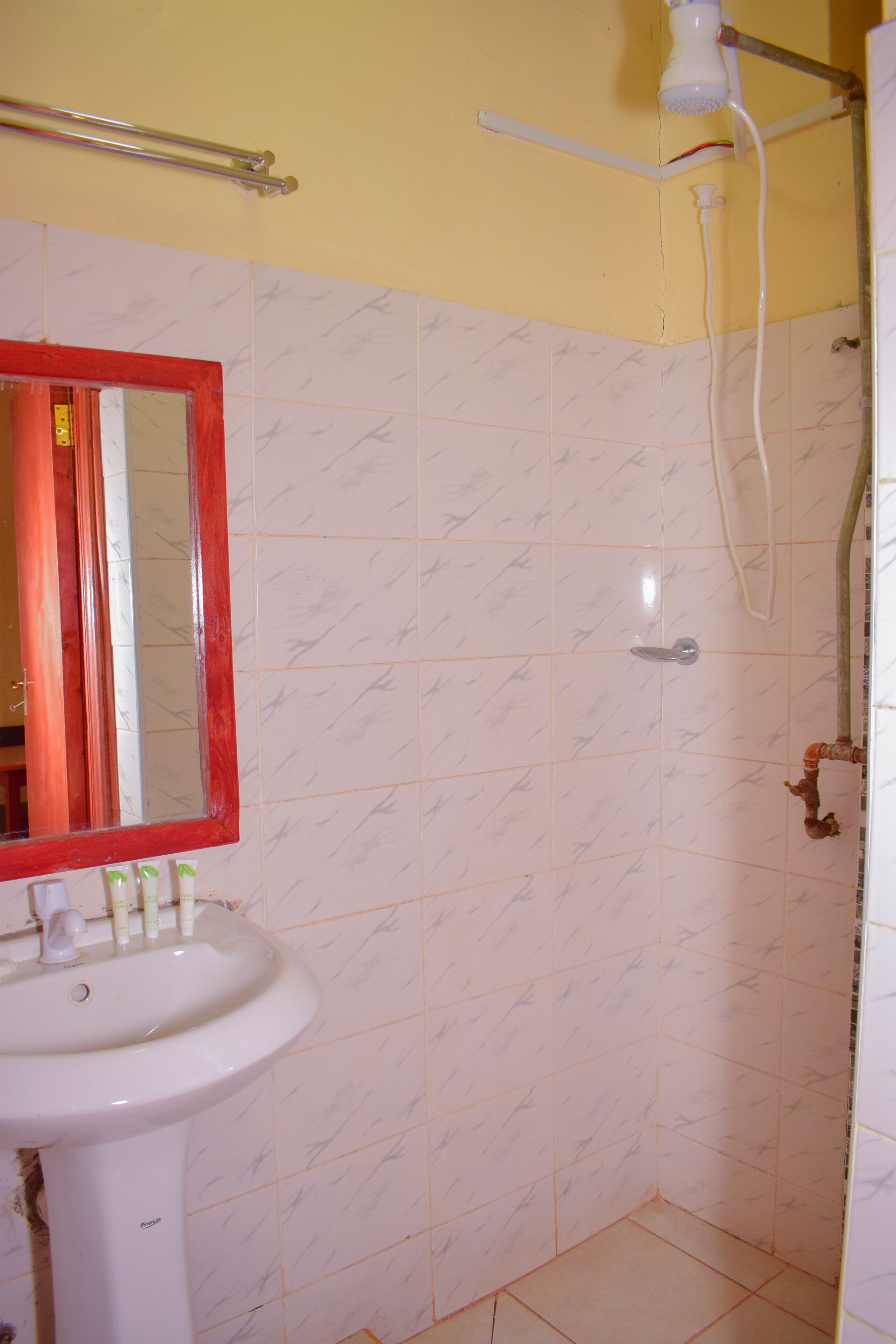Un baño con lavamanos, espejo y ducha.