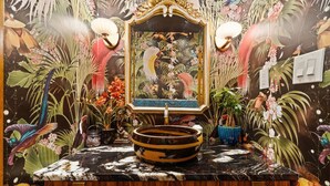 Une salle de bain avec un grand miroir, un lavabo rond et un meuble-lavabo en bois.