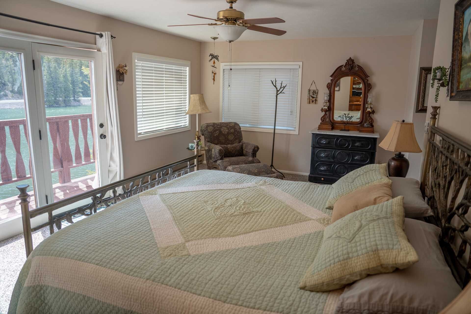 A bedroom with a bed, a chair, a dresser, a ceiling fan, and a window with blinds.