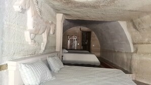 A room with a bed, pillows, and a wall-mounted horse sculpture. - Lucky Cave Cappadocia (Nevsehir)