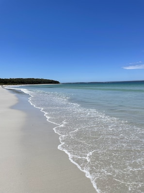 A beach with clear water and a sandy shore.