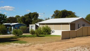 A single-story house with a large garage, a small attached shed, and a fenced yard.