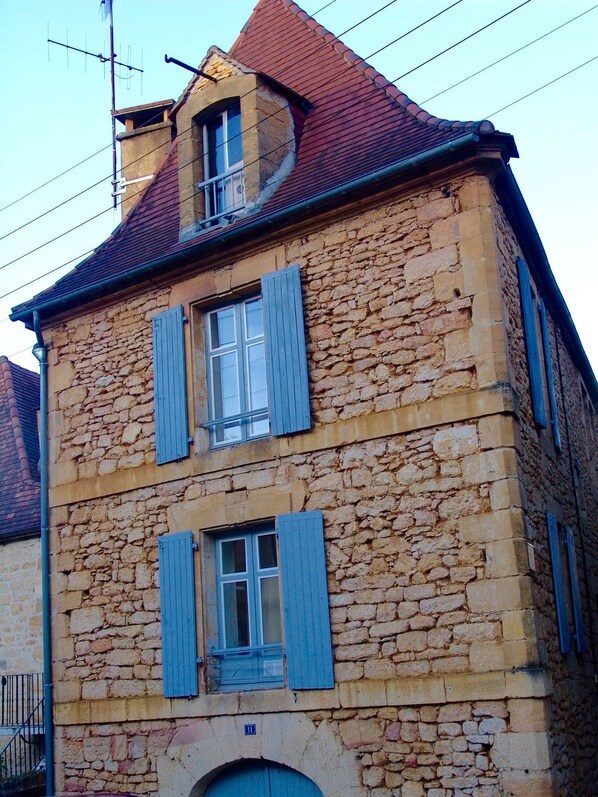 A stone building with two windows and blue shutters. - Apartment in old Medieval  City Center Sarlat (Franreal) (Sarlat-la-Canéda)