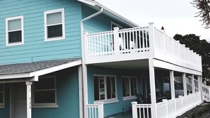 A two-story house with a balcony and a covered porch. - ENTIRE TWO-STORY FRONT BEACH RD HOME PRIVATE POOL & PARKING HUGE BALCONY DECKS (Panama City Beach)