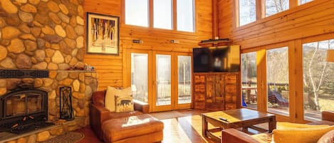 Relax by the fireplace in this inviting living room with leather sofas and a television.