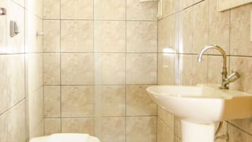 A bathroom with a toilet, sink, and shower.