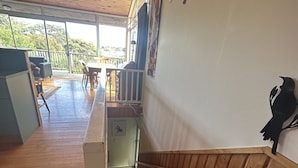 Eine Holztreppe führt zu einem Balkon mit Blick ins Freie.