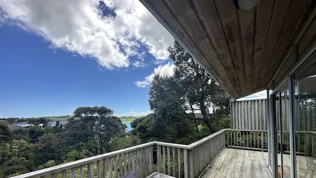 Eine Holzterrasse mit Blick auf einen See und Bäume.