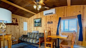 A cozy cabin interior with a wooden ceiling, a ceiling fan, a sofa, a dining table with chairs, a blue rug, and a painting on the wall. - Yellowstone's Treasure Cabin #1, few min drive to Yellowstone Park (Gardiner)