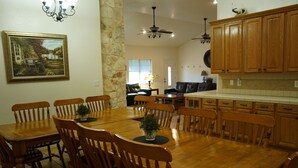 A dining area with a wooden table and chairs, a chandelier, and a painting on the wall. - Country-style Oasis! The perfect family get-away. VIEW OUR VIDEO!  (San Antonio)