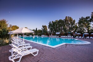 Una piscina al aire libre de temporada, sombrillas