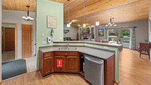 Une cuisine moderne avec des meubles en bois, un lave-vaisselle en acier inoxydable et un grand îlot central doté d’un évier.