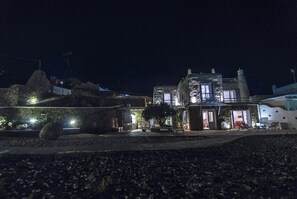 Une maison moderne avec une façade en pierre, un balcon et un espace salon extérieur.