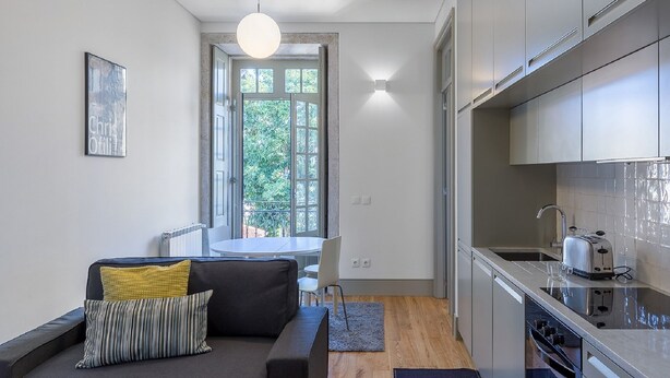 Een knus woongedeelte met een bank, een eettafel en een kitchenette.