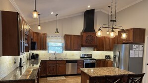 A modern kitchen with wooden cabinets, stainless steel appliances, and a granite countertop. - CONVENIENCE! Steps away to a private dock & 5 miles to a marina/grocery/hwy!    (Caryville)