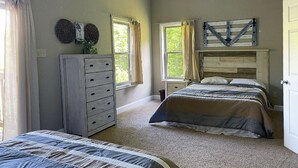 A bedroom with two beds, a dresser, a ceiling fan, and a window with curtains. - CONVENIENCE! Steps away to a private dock & 5 miles to a marina/grocery/hwy!    (Caryville)