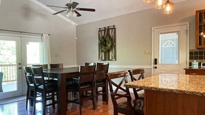 A kitchen with wooden cabinets, a granite countertop, and a dining area with a table and chairs. - CONVENIENCE! Steps away to a private dock & 5 miles to a marina/grocery/hwy!    (Caryville)