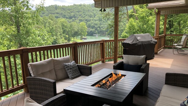 A covered outdoor deck with wicker furniture, a fire pit, and a grill. - CONVENIENCE! Steps away to a private dock & 5 miles to a marina/grocery/hwy!    (Caryville)