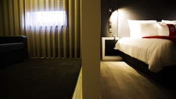Une chambre d’hôtel avec un lit, une table de chevet et une fenêtre avec des rideaux.