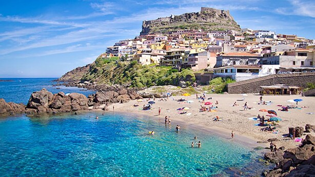 A coastal town with a prominent hilltop fortress, clear turquoise waters, and a sandy beach with umbrellas. - Luxury apartment with stunning sea views and close to sea and shops, WI-FI,clima (Castelsardo)
