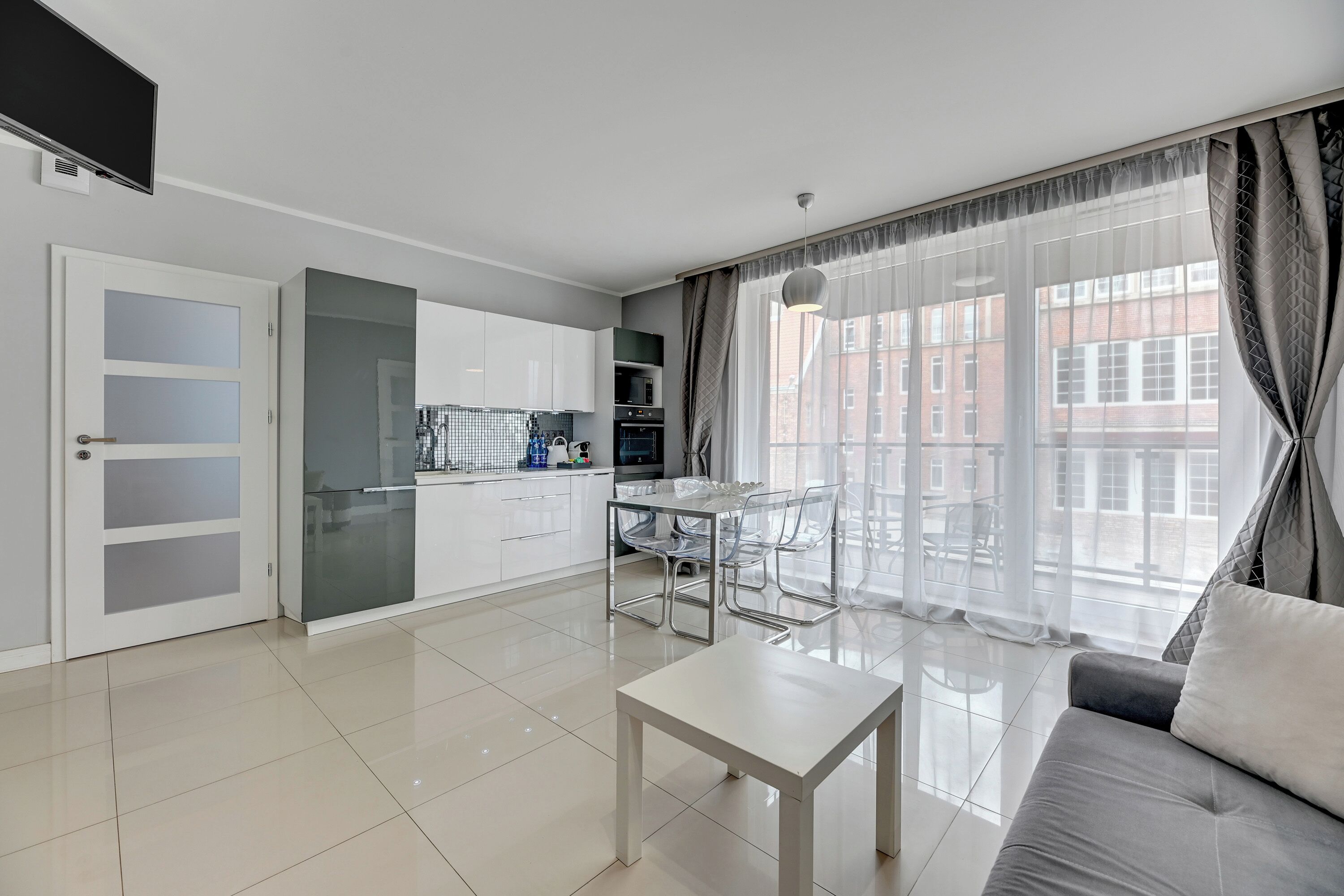 A modern apartment with a kitchen, dining area, and living room.