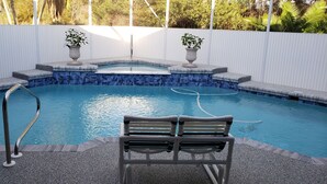 A swimming pool with a built-in hot tub, two potted plants, and a bench. - Special summer discounts available NOW! Family-Friendly Heated Pool Escape (Land O' Lakes)