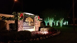 A sign for Grand Oaks, a deed-restricted community, with a brick wall and greenery. - Special summer discounts available NOW! Family-Friendly Heated Pool Escape (Land O' Lakes)