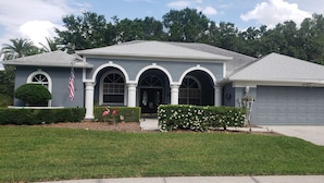 A residential house with a grey roof, white columns, and a garage. - Special summer discounts available NOW! Family-Friendly Heated Pool Escape (Land O' Lakes)