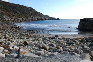 A rocky beach with large boulders and a cliff in the background. - Sparrows Nest - Three Bedroom Cottage, Sleeps 6 (Paul)