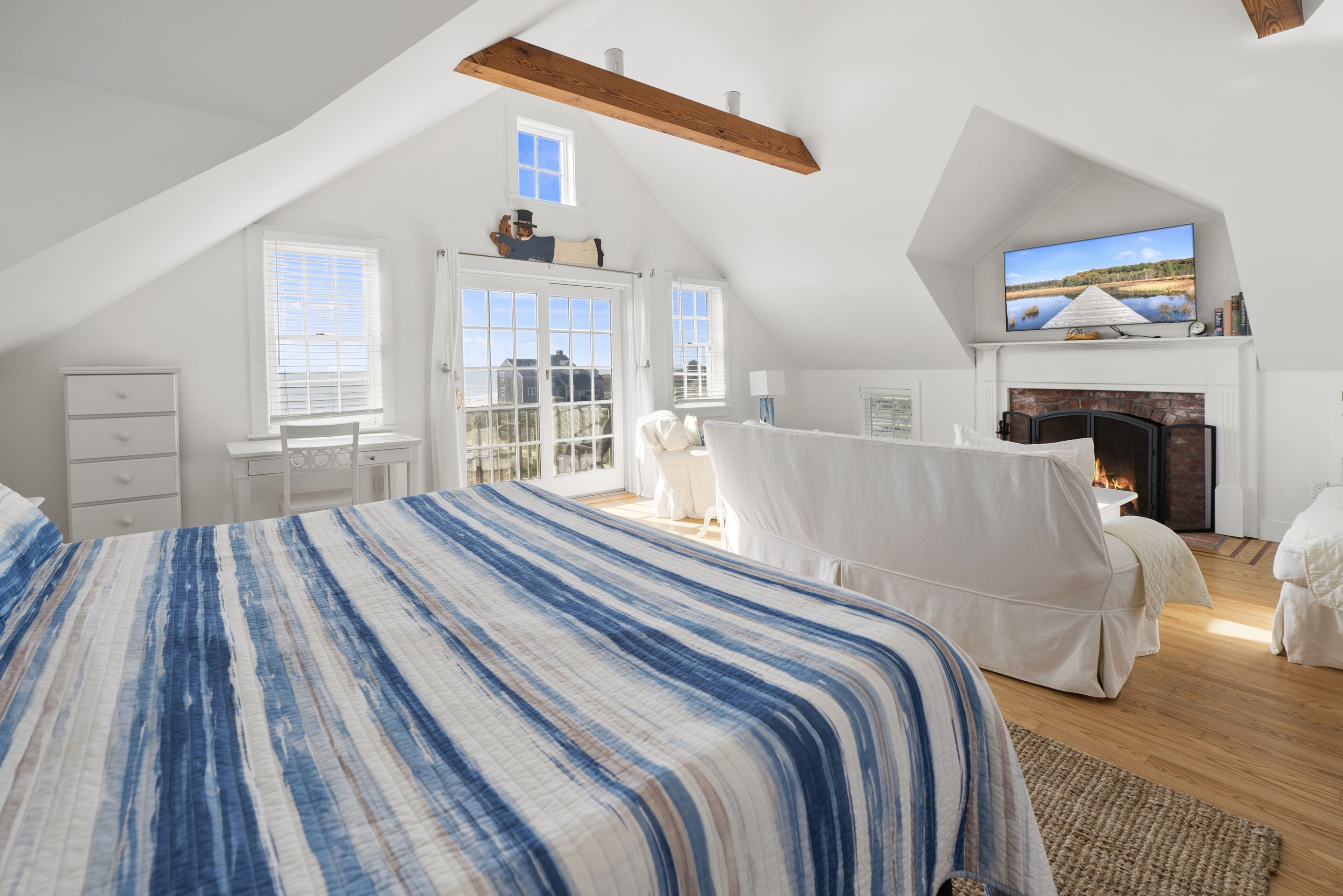 Een slaapkamer met een groot bed, een open haard en een televisie.