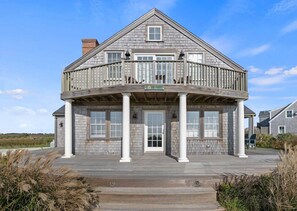 A two-story house with a balcony, a front porch with columns, and a sign that reads 'LIVE SWIM'.